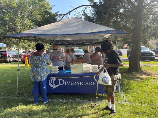 Residents and staff engaging at an outdoor event tent