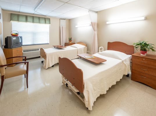 A shared resident room with two beds and furnishings