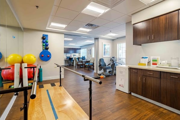Therapy room with rehabilitation equipment and chairs
