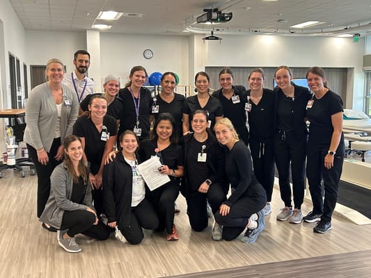 Staff members posing together in a bright therapy room