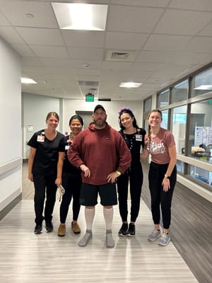 Staff and resident posing together in a hallway