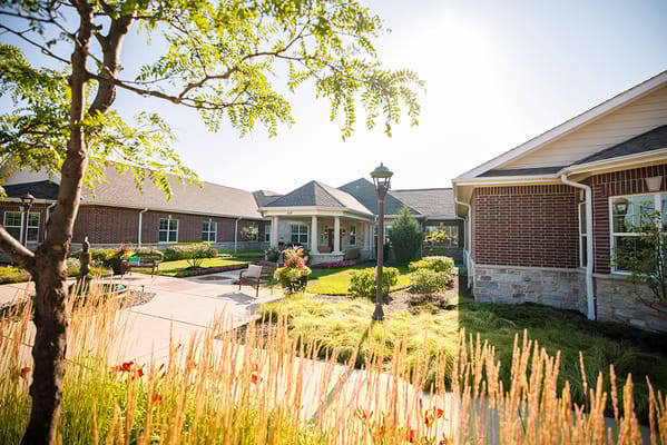 Exterior view of Encore Memory Care facility with gardens