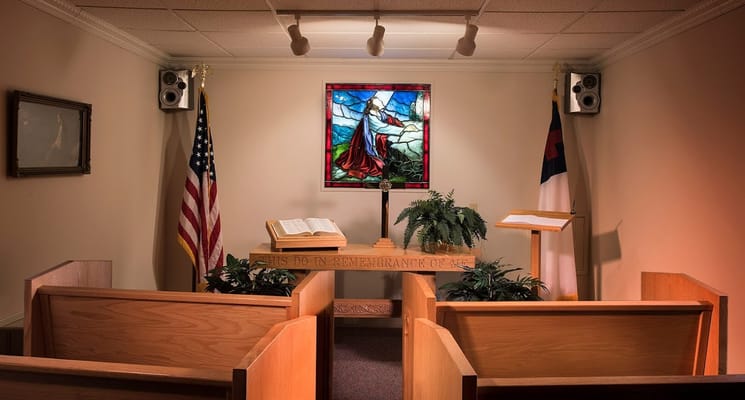 Interior view of a chapel with wooden pews