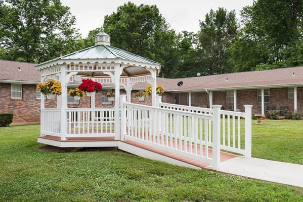 Outdoor gazebo with flowers in a spacious lawn