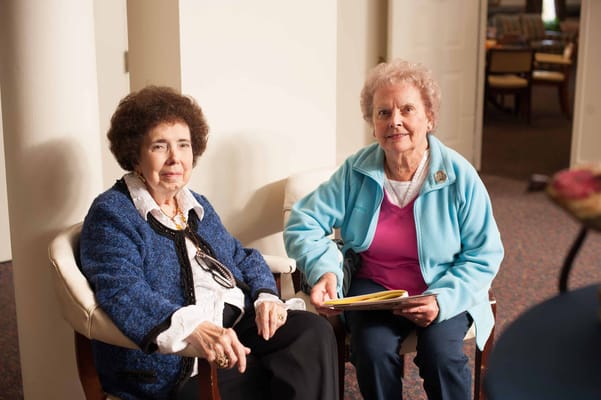 Two residents enjoying a conversation in a lounge area