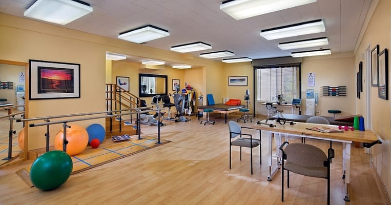 Physical therapy room with equipment and exercise mats