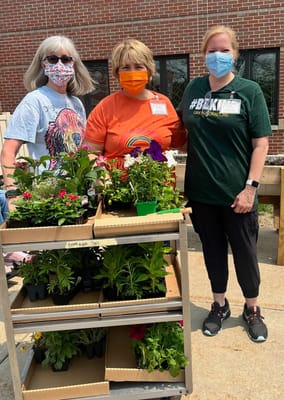 Residents and staff posing with flowers in a garden