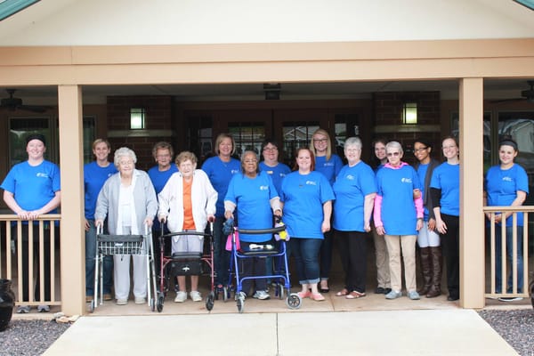 Group photo of staff and residents in front of the facility