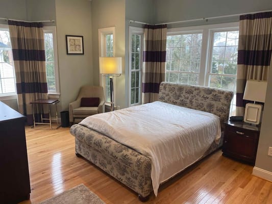 Bright and inviting bedroom with a large window and comfortable furnishings.