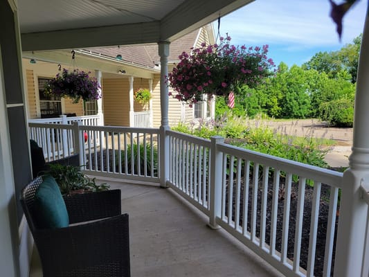 Welcoming porch area with hanging flowers and seating