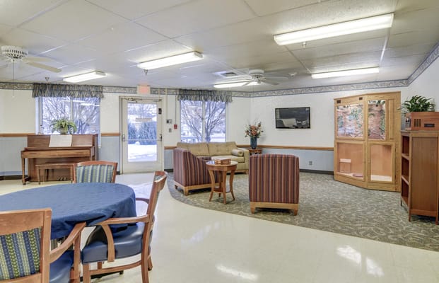 Bright common area with seating and a piano