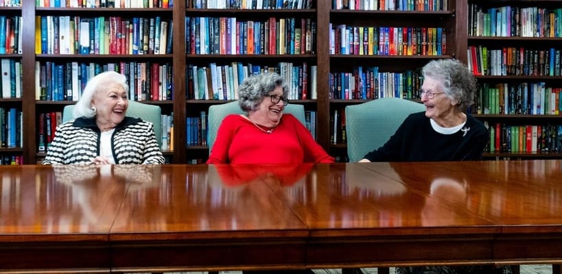 Three residents laughing together in a common area