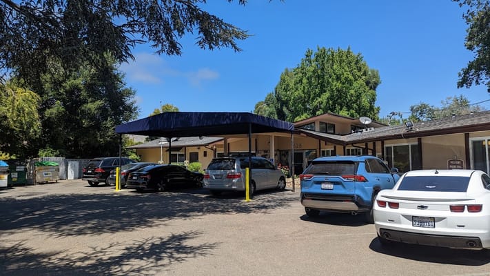 Exterior view of the facility entrance with parked vehicles