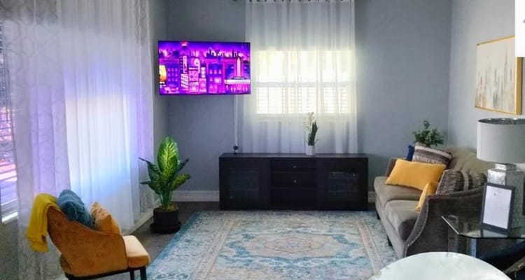 Bright common area with a couch and TV