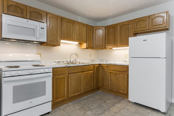 Spacious kitchen with wooden cabinets and appliances