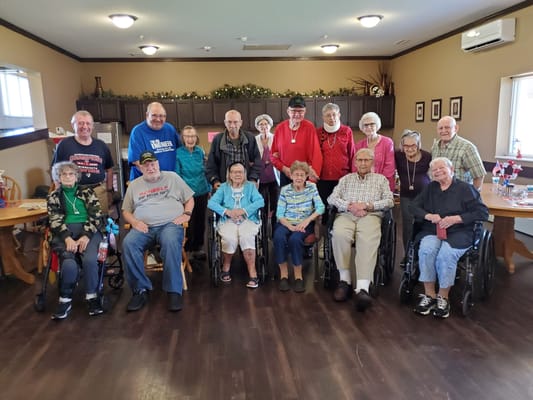 A group photo of senior residents in the community room at Ingleside Inc.