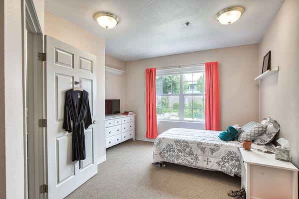 Interior view of a private resident room with bed and furniture