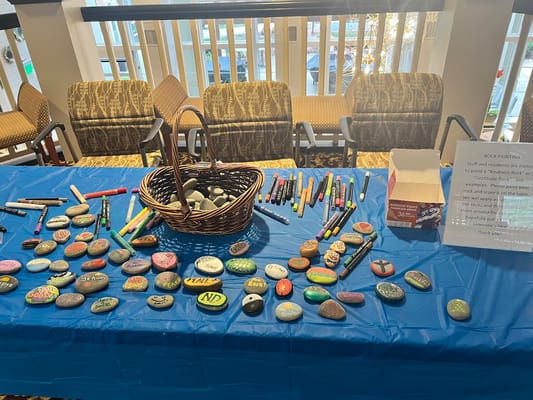 Table with painted rocks and art supplies for residents