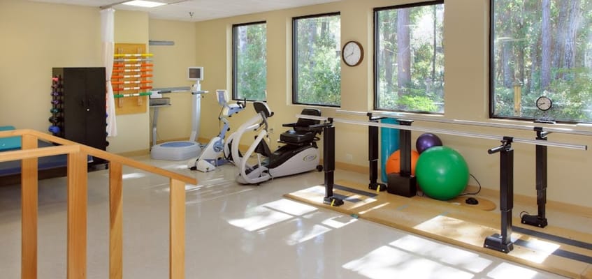 Well-equipped therapy room with exercise equipment and natural light