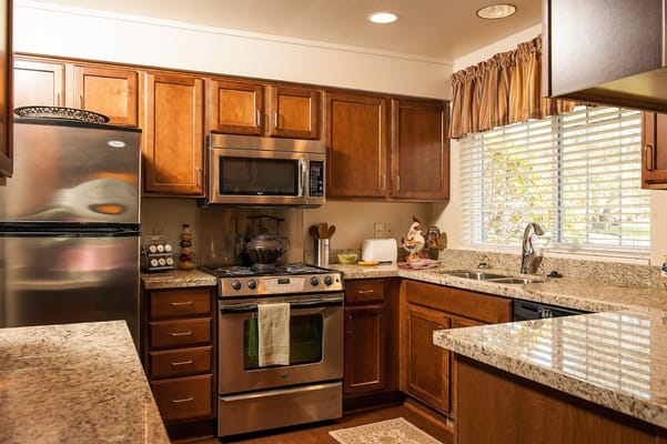 Modern kitchen interior with wooden cabinets and granite countertops