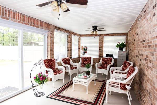 Cozy sunroom with wicker chairs and potted plants