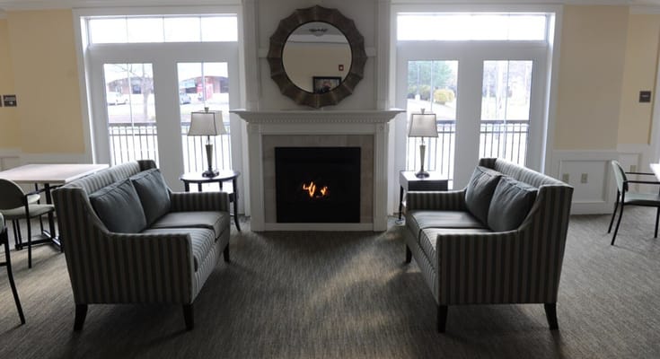 Lounge area with striped sofas, fireplace, and large windows
