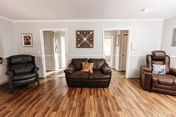 Cozy living room with two sofas and a recliner