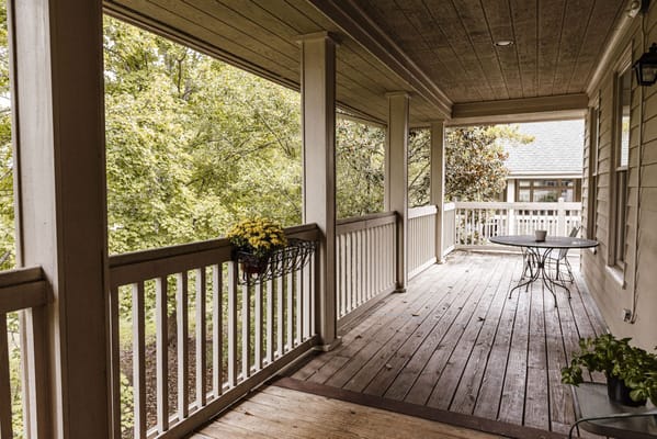 Covered porch area with plants and seating