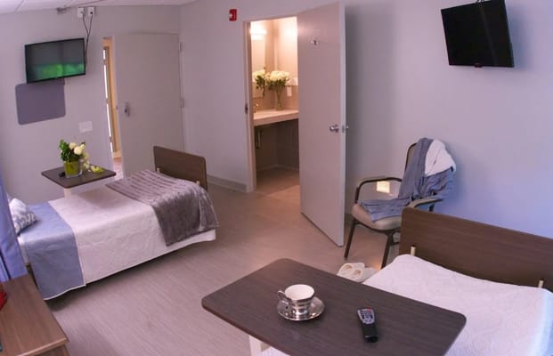 Private resident room with two beds and a shared bathroom
