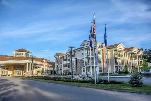 Exterior view of a senior living facility with flags