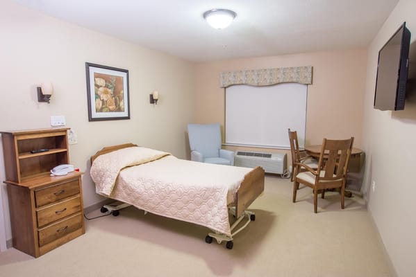 Interior view of a private resident room with a bed and chair