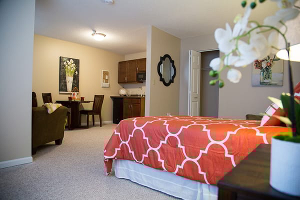 Cozy interior of a resident's room with a bed and seating area
