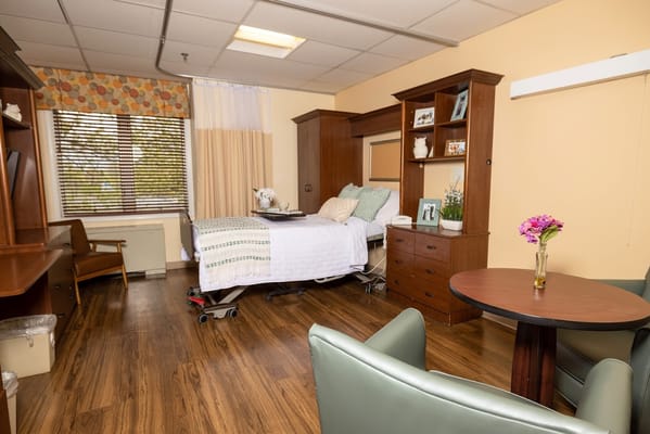 Spacious bedroom with a hospital bed and seating area