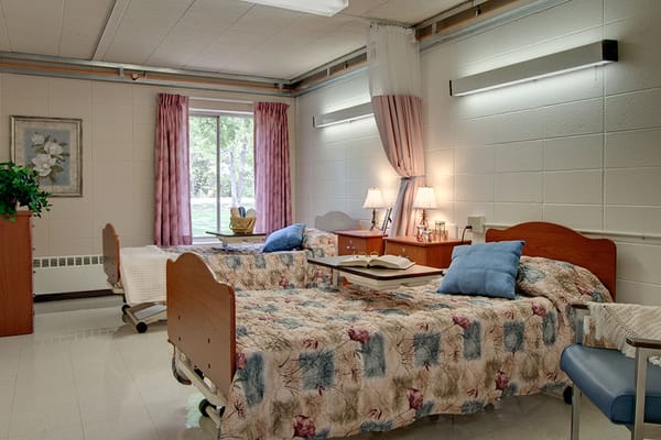 A shared resident room with two beds and natural light