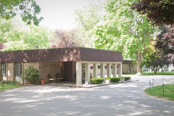 Exterior view of a senior living facility surrounded by trees