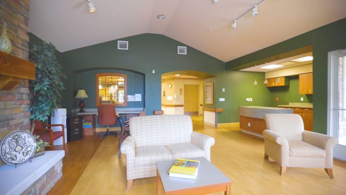 A cozy common area with seating and a green wall