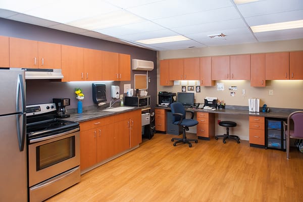 Interior view of an office at Morning Breeze Retirement Community, featuring wood cabinets and modern appliances.