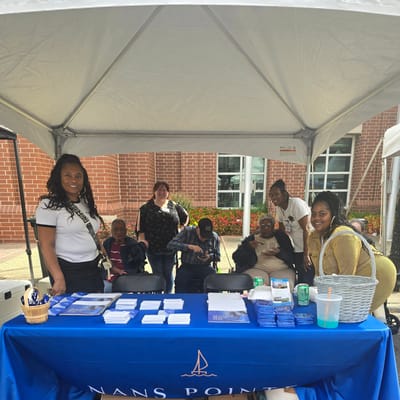 Staff and residents at a community event under a tent