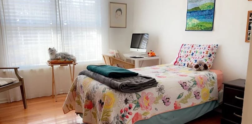 Bright bedroom with floral bedding and desk