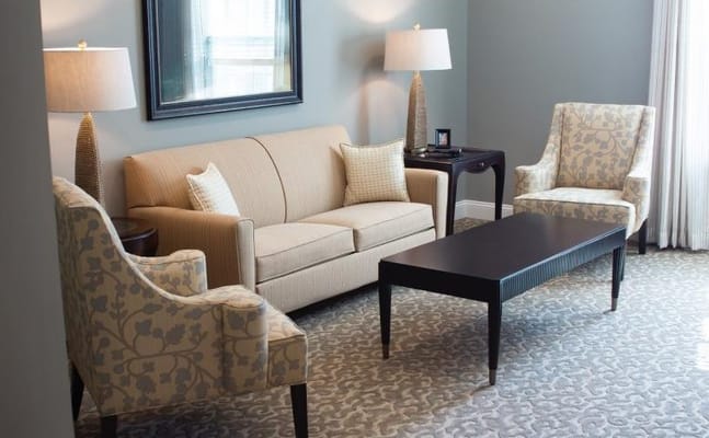 A cozy living room with a beige sofa and patterned armchairs