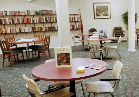 Interior view of a common area with bookshelves and tables