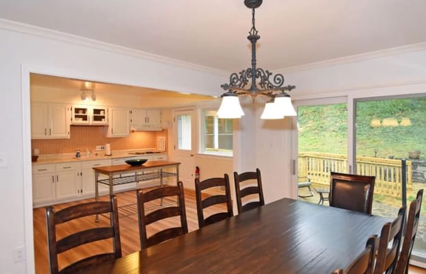 Bright dining area with large table and kitchen view