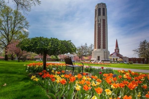 Colorful tulip flowers in front of a clock tower at Peabody Retirement Community.