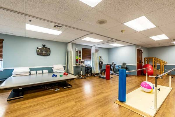 Well-equipped therapy room with exercise equipment and therapy table