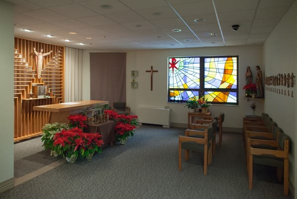 Interior chapel with decorative stained glass and seating
