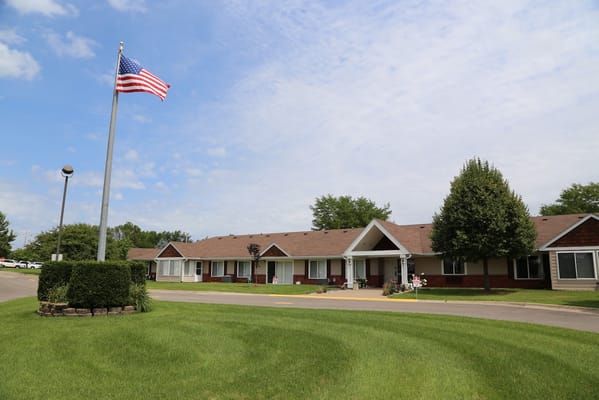Exterior view of Regency Retirement Residence with a flag and landscaped area.