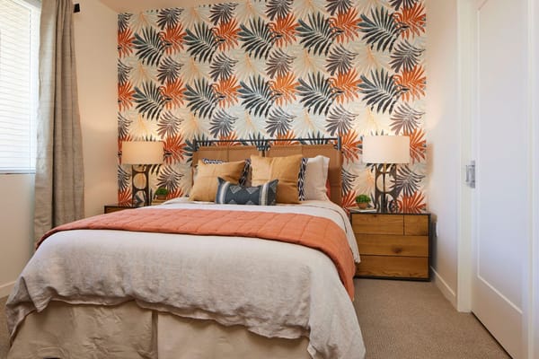 Stylish bedroom with palm leaf wallpaper and warm-toned decor