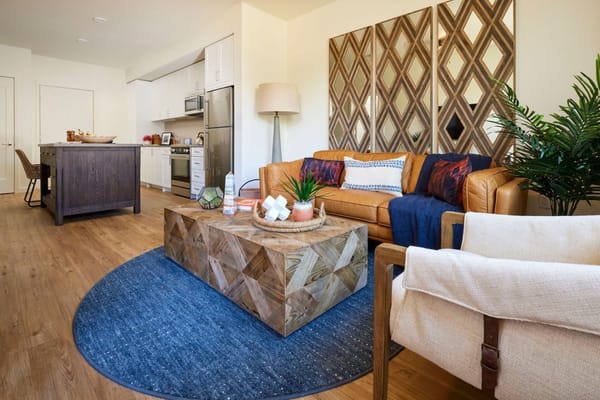 Bright and inviting living room area with a leather couch and decorative coffee table.