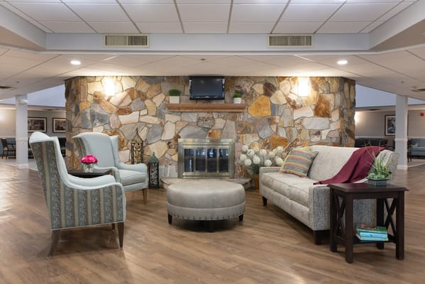 Cozy lounge area with seating and a stone fireplace