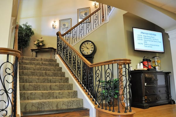 Staircase leading to upper levels with a clock and activity schedule